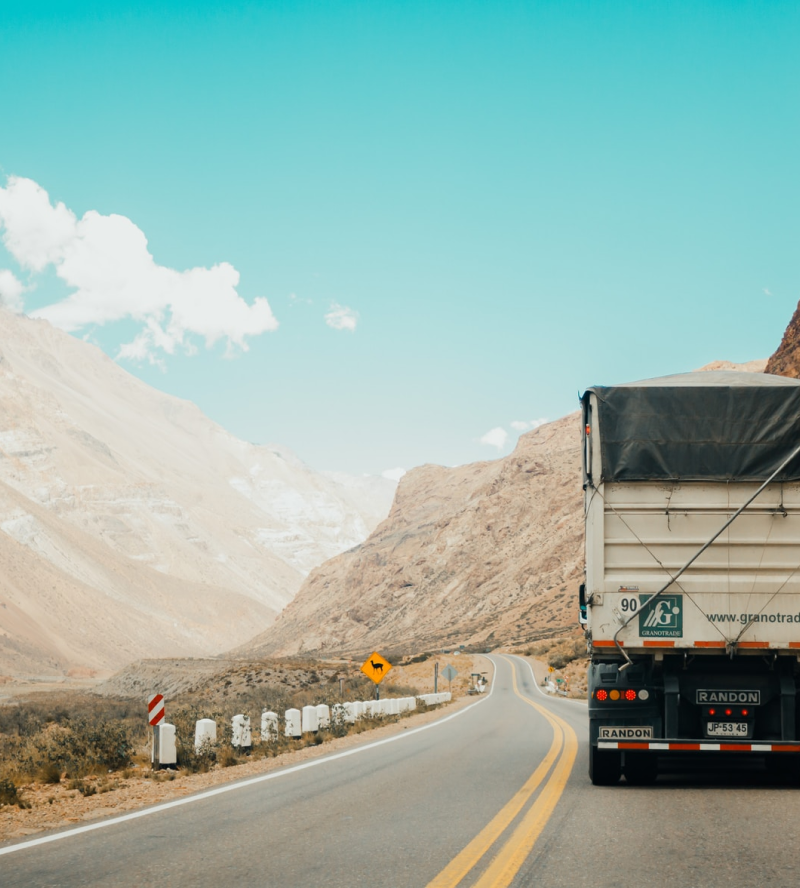 Camión de carga transitando una carretera que atraviesa el desierto